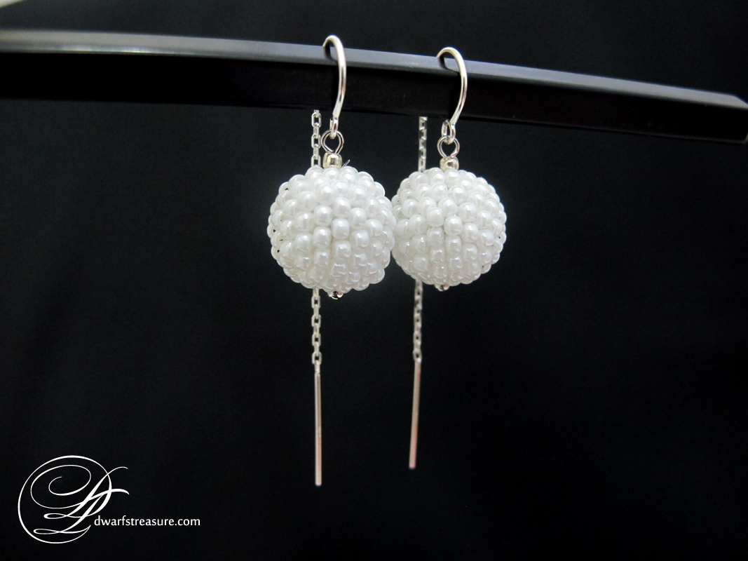 white seed beaded bead balls earrings on black background