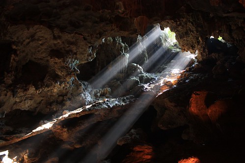 sun rays peak through a cave in Ha Long Bay
