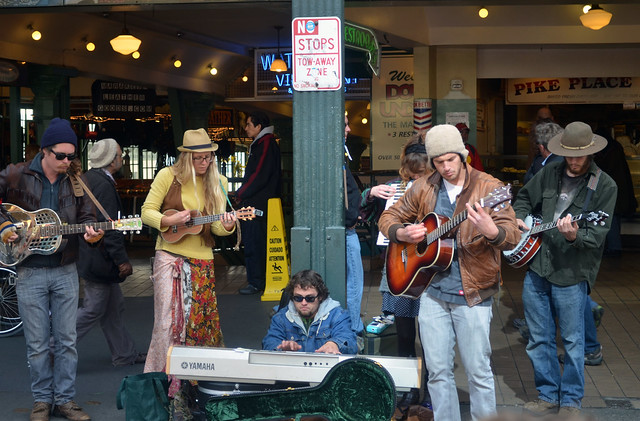 A small group of people playing music, with a variety of instruments. 