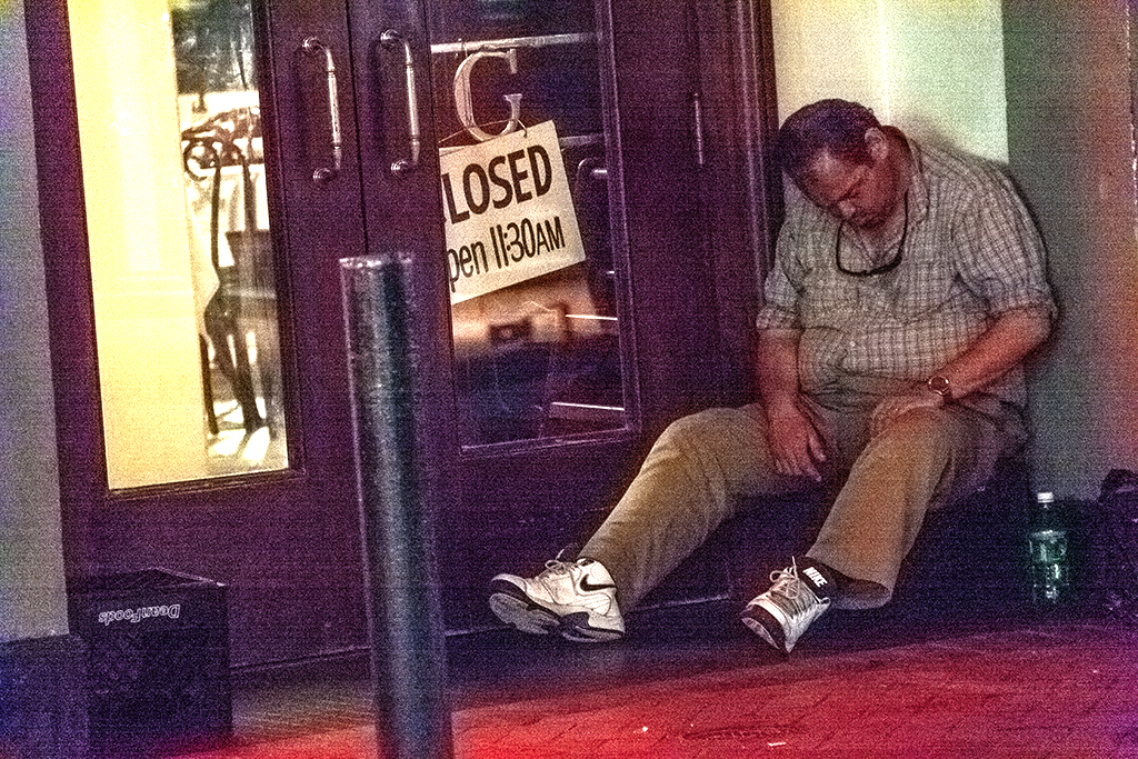 Man-sleeping-in-front-of-CLOSED-sign-on-3-16-12--New-Orleans