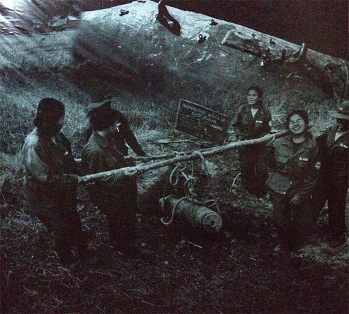 photo of a photo in the MAG office. locals extracting a bomb from the ground