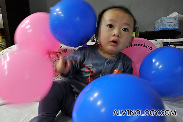Asher playing with balloons, wearing a Merries diaper