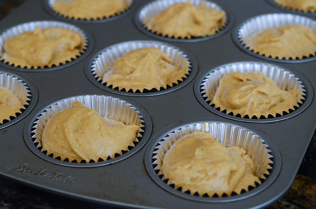 Cupcake batter is added to a muffin tin.