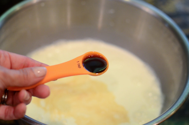A measuring spoon with vanilla extract in it.