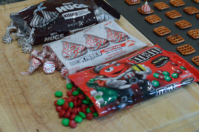 Christmas themed M&M's and Hershey's Kisses on a cutting board.