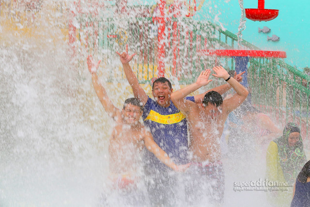 The boys from METROPOLITANT.com and SUPERADRIANME.com getting 350 gallons of water poured on them in the wade pool at LEGOLAND Malaysia Water Park's Joker Soaker attraction.