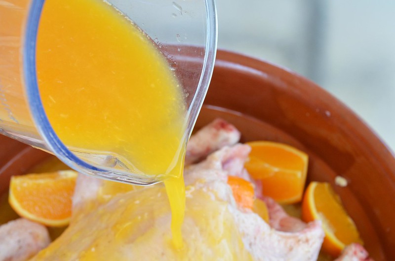Foto echándole al pollo el zumo de naranja