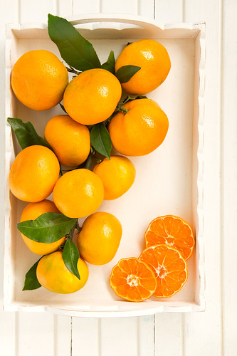 tangerines on light background in a wooden box.