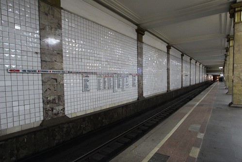 Directional signage on the tunnel wall located opposite the waiting passengers