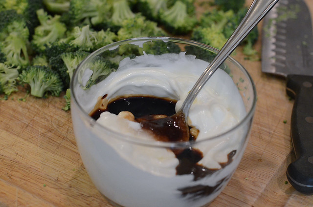 Balsamic vinegar is added to dressing in a bowl.