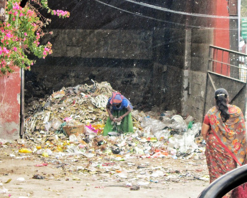 Poor woman in rubbish pile, India