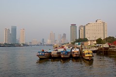 Bangkok skyline in the evening with express boats seen from Asiatique - The riverfront by the Chao Phraya river in Bangkok, Thailand
