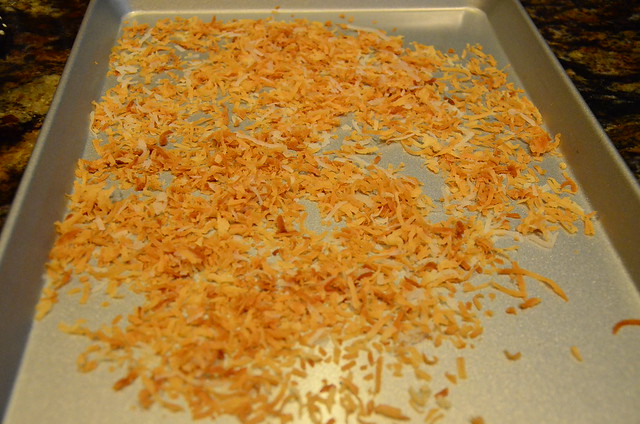 A baking sheet with toasted coconut flakes on top.