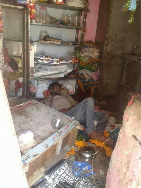 Injured man lying in his vandalized business.