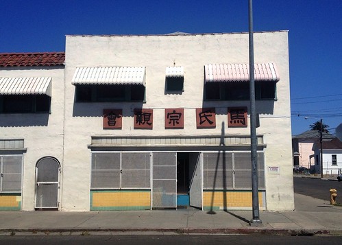 street blue shadow sky building face sign architecture corner tile landscape asian store eyes downtown chinatown cityscape view decorative empty chinese entrance pole neighborhood sidewalk lettering stockton facesinplaces
