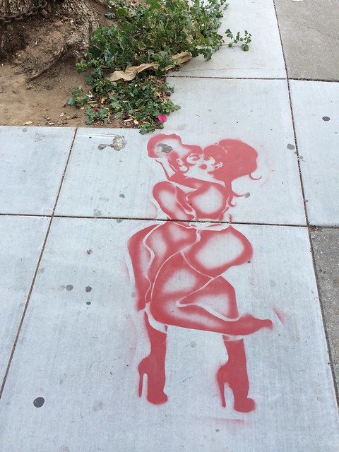 Women kissing sidewalk stencil