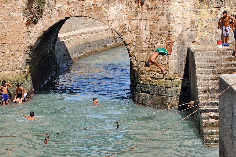 ESSAOUIRA - SEPTEMBER 29: Children take a bath in the canal. Essaouira, Morocco, September 29, 2013.