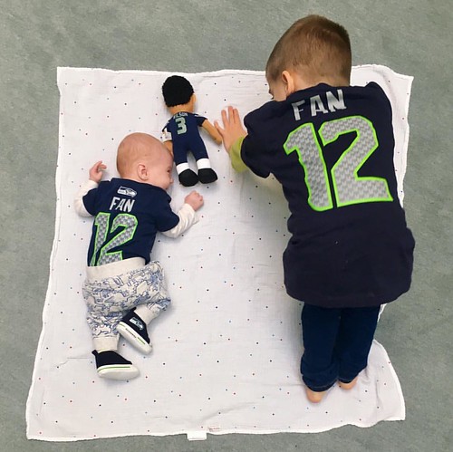 We're ready for tonight's #seahawks game thanks to @hawkknitter. These brotherly moments are my favorite! LB is showing his lil bro how to do tummy time like a boss. Yes, that is a Russell Wilson toy from @whendragonscry #12thman #kakaaww #gohawks #ig_mo