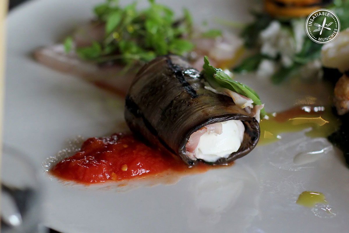 Part of an antipasto platter. Goats' cheese is rolled in marinated eggplant, and served cold with a light tomato sauce.