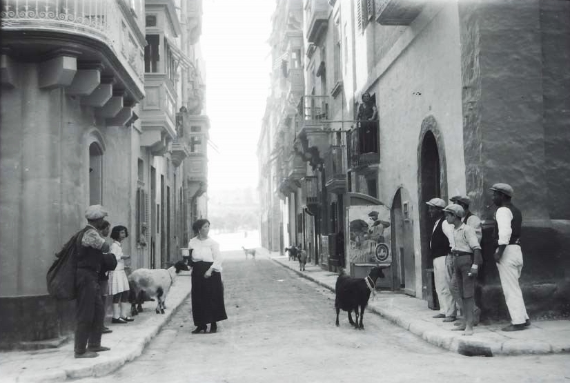 Goat milk seller and customer with local people in either Floriana or maybe Valletta Malta in 1933