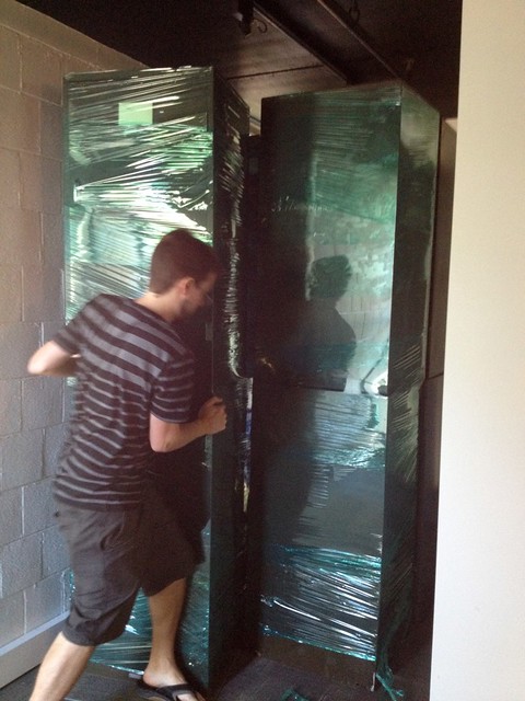 man moving metal insect cabinets wrapped in plastic