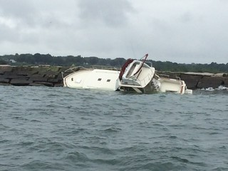 A 38-foot pleasure craft sits atop of the east breakwall inside Conneaut Harbor, Conneaut, Ohio, July 23, 2014. The responsible party has established a salvage plan. (U.S. Coast Guard photo)