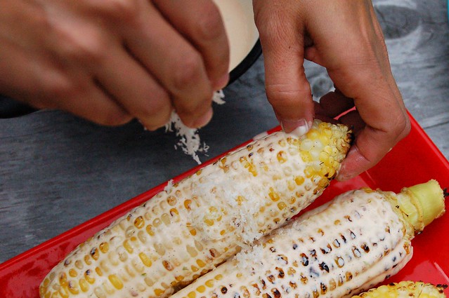Sprinkling the corn ears with cheese by Eve Fox, The Garden of Eating, copyright 2014