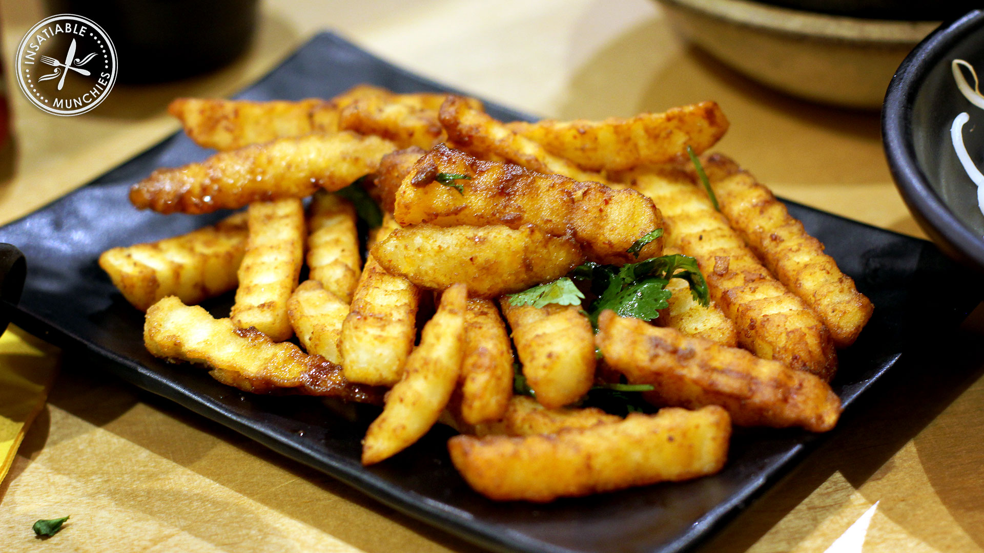 Crinkle cut fries are deep fried and tossed in a fermented bean paste based sauce. 