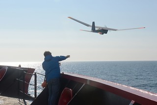 John Ferguson, an Unmanned Aircraft System operator for AeroVironment, releases a Puma All Environment UAS from the deck of the Coast Guard Cutter Healy during an exercise in the Arctic Aug. 23, 2014. The Puma is a small UAS designed for land and maritime operations. (Coast Guard photo by Petty Officer 1st Class Shawn Eggert)