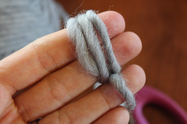 Begin by winding the wool yarn around your two fingers.