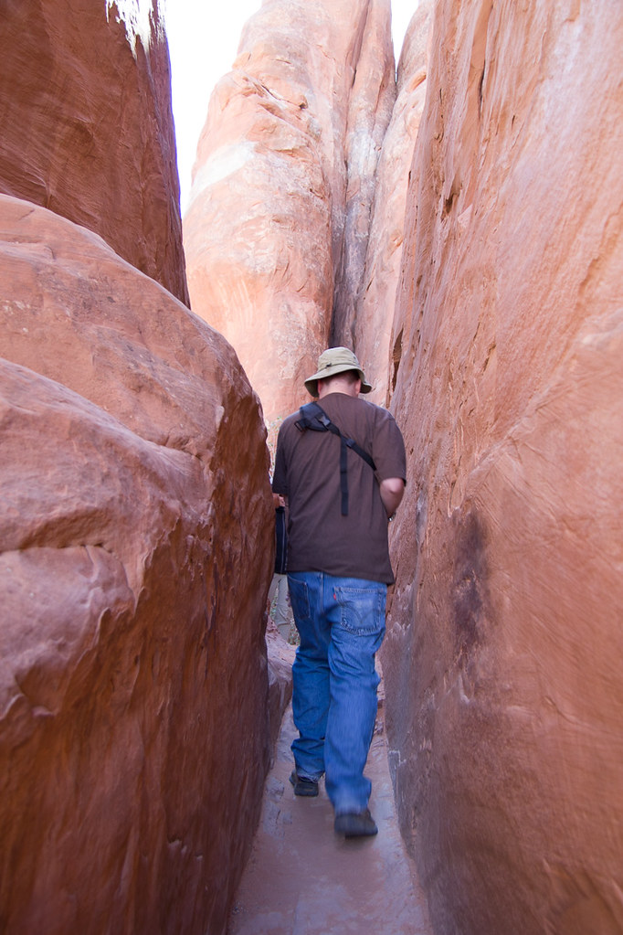 Ken squezing through during hike to Sand Dune Arch at Arches National Park