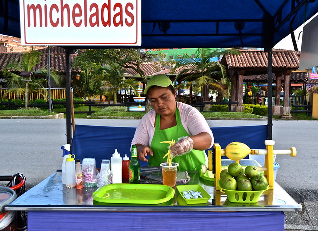 making michelada colombiana in a food stand by a street vendor