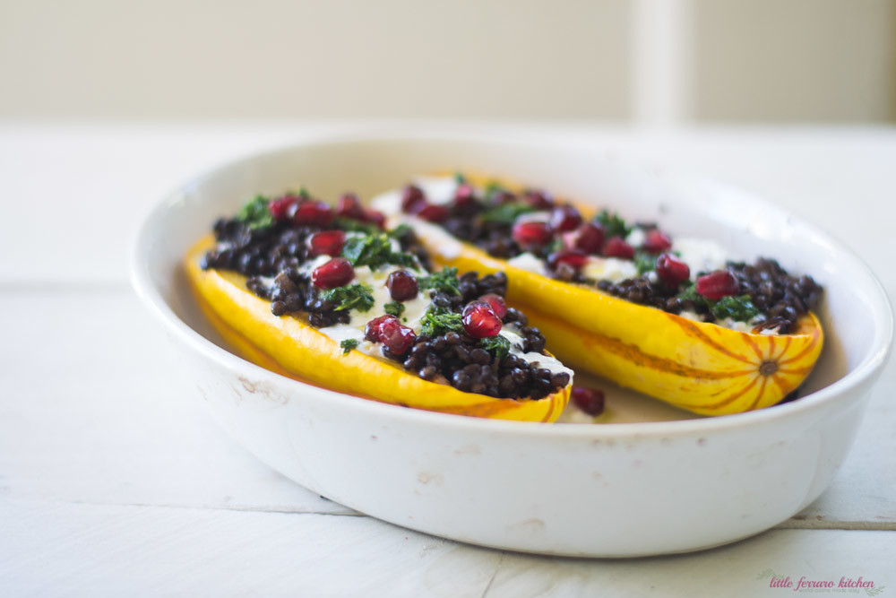Stuffed delicata squash is flavored with bold Mediterranean flavors of cumin lentils, creamy yogurt feta sauce and sweet pomegranate seeds.