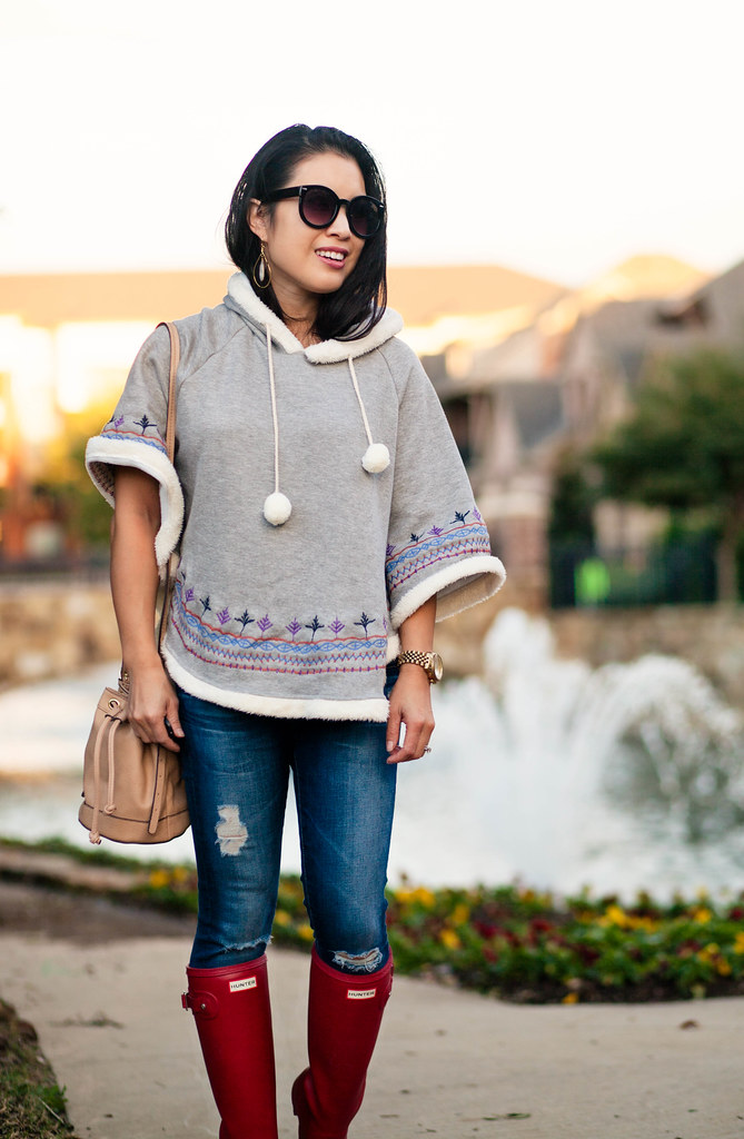 cute & little blog | petite fashion | knit pom pom poncho, distressed denim, red hunter tour boots | fall outfit