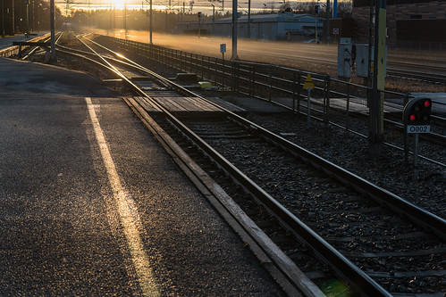 railroad light sunset station sign fog suomi finland track crossing pavement rail railway pylon beam catenary karis karjaa skrubu pni pekkanikrus