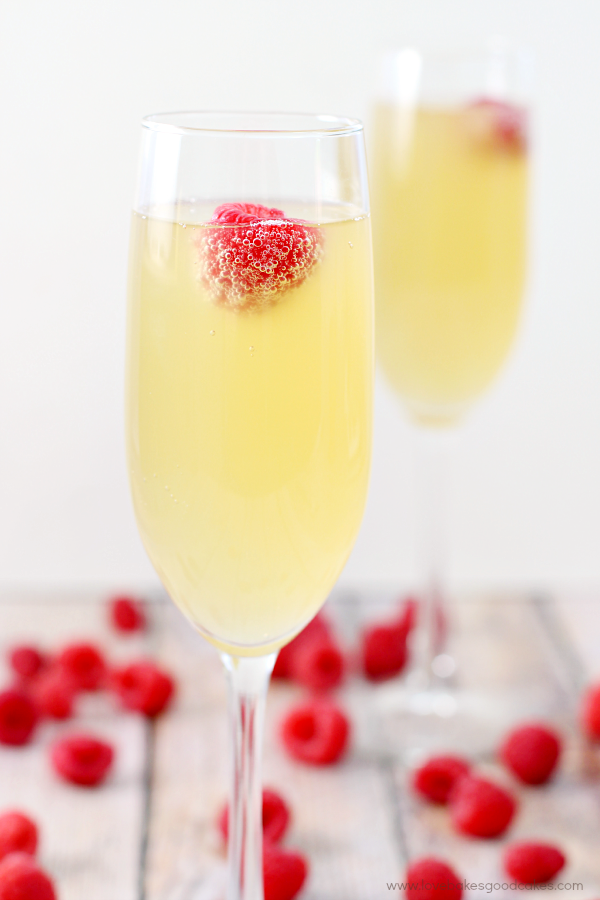 Mock Champagne Punch in two glasses with fresh raspberries.