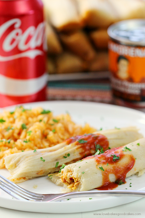 Chipotle Chicken Tamales on a plate with Mexican rice, a fork, and a can of Coca Cola.