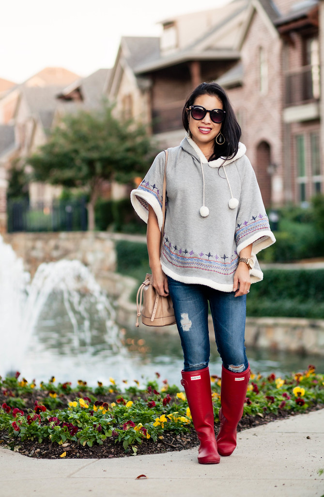 cute & little blog | petite fashion | knit pom pom poncho, distressed denim, red hunter tour boots | fall outfit