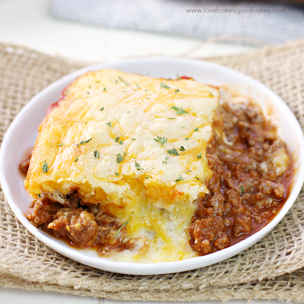 Cheesy Sloppy Joe Bake on a plate with a piece removed.