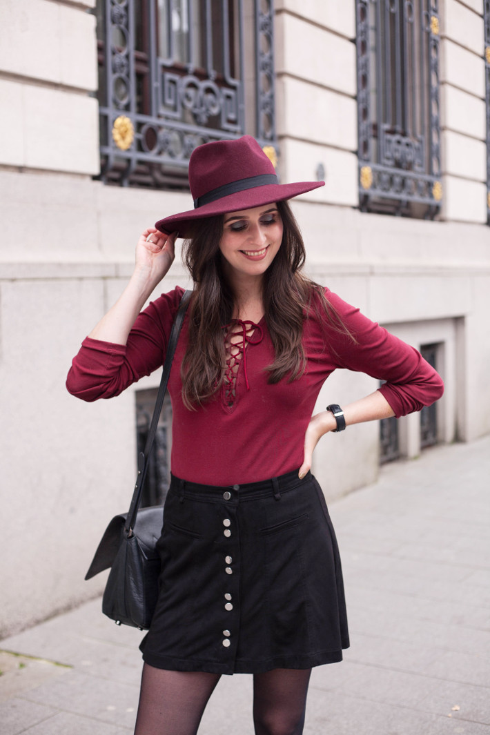 outfit: burgundy hat, lace up top, button down skirt 