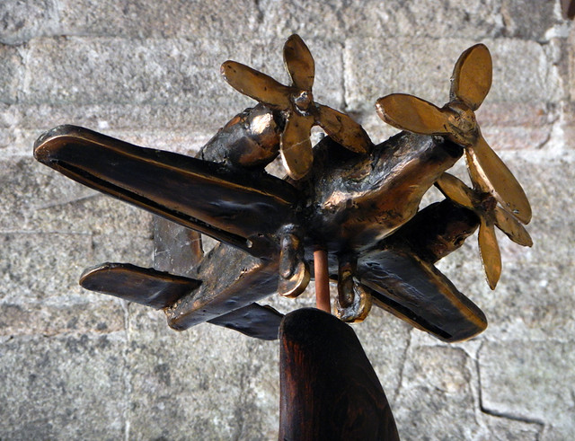 A bronze sculpture of an airplane in the permanent art show