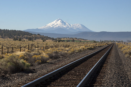 california railroad blue sky plants mountain train fence landscape volcano highway tracks brush sage snowcapped shasta plains dormant