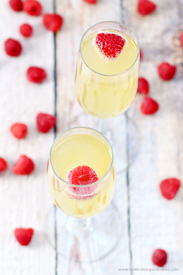 Mock Champagne Punch in two glasses with fresh raspberries.