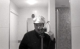 reflected self-portrait with Canonet QL17 camera and blingy cap