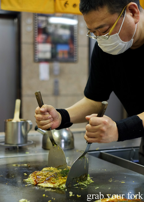 Cutting up our Hiroshima-style okonomiyaki at Okonomimura, Hiroshima