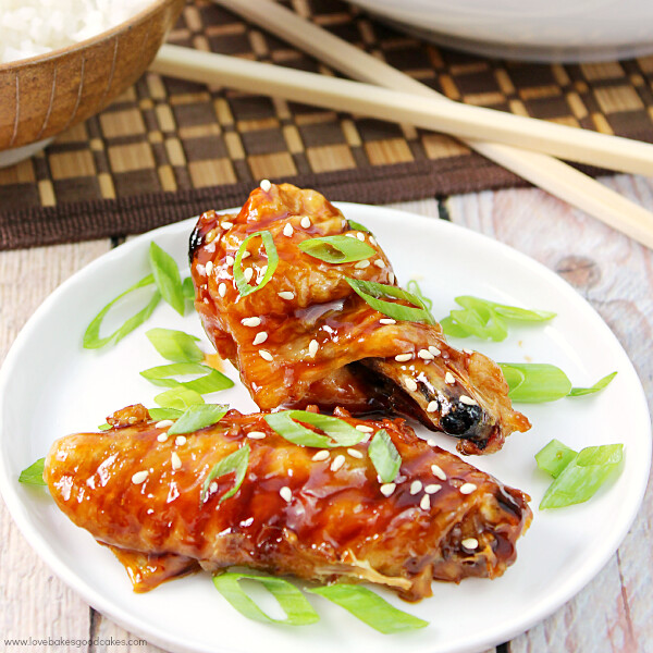 Asian Sticky Wings on a white plate with chop sticks.