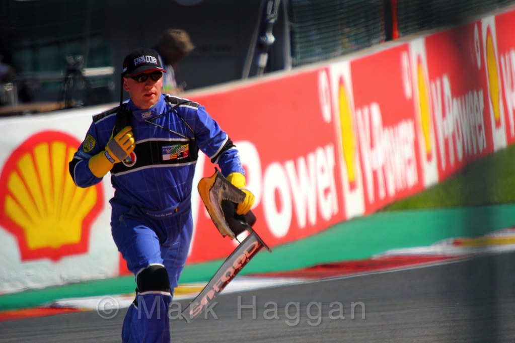 A marshal recovers debris in the GP2 feature race at the 2015 Belgium Grand Prix