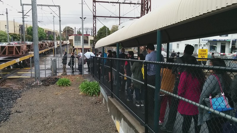 Glenhuntly station: passengers waiting for passing freight train