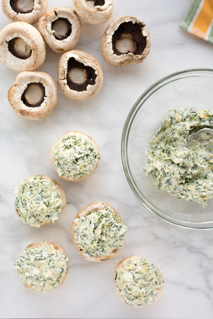 filling mushrooms with spinach and artichoke dip