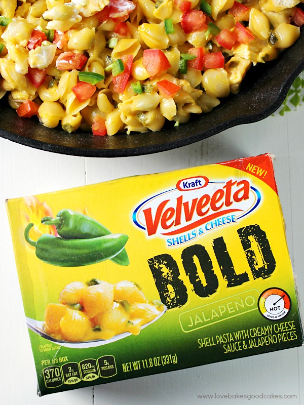 Fiesta Mac & Cheese in a skillet and a package of Velveeta Bold cheese.